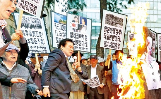 < “日 역사왜곡 중단하라” > 대한어버이연합과 보수국민연합 회원들이 25일 서울 중학동 주한 일본대사관 앞에서 일본의 역사왜곡을 규탄하는 집회를 열고 아베 신조 총리의 이름이 붙은 인형에 불을 지르고 있다. 연합뉴스