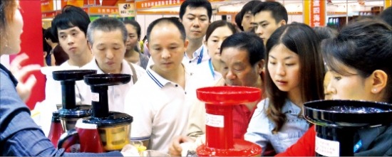 중국 관람객들이 휴롬의 원액기 제품을 살펴보고 있다.  