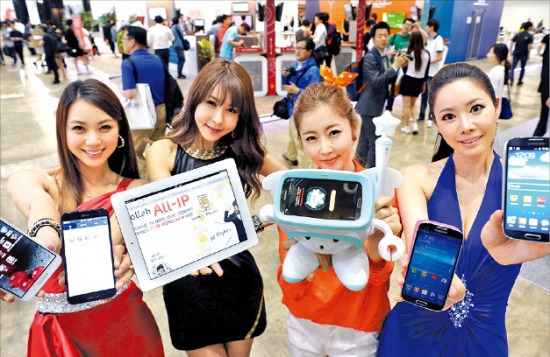 21일 ‘월드 IT쇼(WIS)’에서 LG전자(왼쪽부터), KT, SK텔레콤, 삼성전자 도우미들이 자사 제품을 소개하고 있다. 신경훈 기자 nicerpeter@hankyung.com