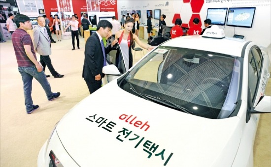 ‘월드 IT쇼 2013’ 둘째 날인 22일, 관람객들이 KT가 출품한 스마트 전기택시 서비스를 체험해보고 있다  /신경훈 기자 nicepeter@hankyung.com 