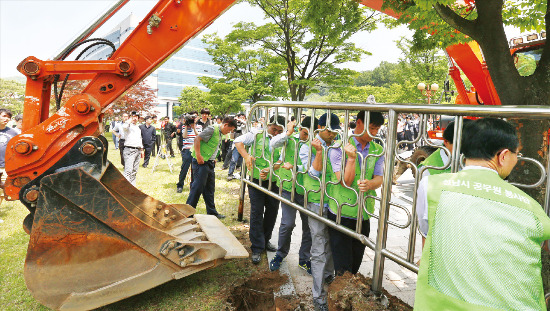 판교 재개발 이주단지 임대 공급문제를 놓고 경기도 성남시와 LH(한국토지주택공사)가 마찰을 빚고 있는 가운데 성남시청 관계자들이 성남시 정자동 LH 사옥 정문의 접이식 시설과 펜스를 불법 시설물이라며 철거하고 있다. 연합뉴스