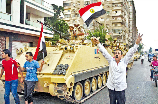 이집트 카이로대 거리에 모인 반정부 시위대가 3일(현지시간) 무함마드 무르시 대통령의 축출 소식을 접한 뒤 환호하고 있다. 이집트 군부는 최후통첩 시간이 지난 지 네 시간 만에 무르시의 권한을 박탈하고 카이로 등 주요 거점도시에 탱크와 군인을 배치했다. 카이로AFP연합뉴스