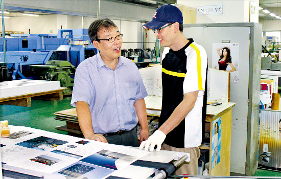 조병욱 삼성문화인쇄 사장(왼쪽)이 책을 만드는 설비 앞에서 직원과 품질 관리에 대해 얘기하고 있다.  /김낙훈 기자 
