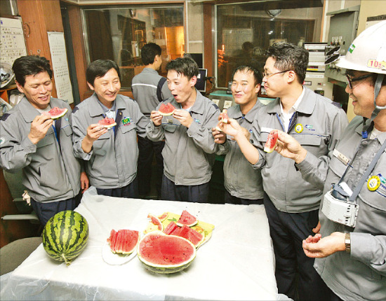 두산중공업 창원 공장 근로자들이 수박을 먹으며 더위를 식히고 있다.  /두산그룹 제공 