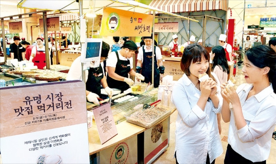 신세계백화점 본점이 11일 마련한 ‘유명시장 맛집 먹거리전’에서 소비자들이 씨앗호떡을 먹고 있다. 전국 전통시장 맛집 8곳을 초청한 이번 행사는 오는 15일까지 열린다. 강은구 기자 egkang@hankyung.com