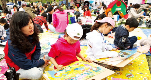 롯데백화점이 메세나 활동의 하나로 지난 4월 개최한 ‘롯데 환경 미술대회’에서 어린이 참가자가 그림을 그리고 있다.  롯데백화점 제공 