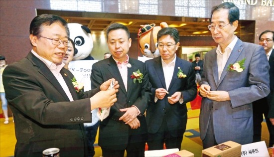 이동필 농림축산식품부 장관(왼쪽부터), 쩡룽 중국 톈룽기업 집행이사, 윤상직 산업통상자원부 장관, 한덕수 무협 회장이 22일 서울 삼성동 그랜드인터컨티넨탈호텔에서 열린 ‘중국 농식품 바이어 초청 수출상담회’에서 한국 중소기업의 농식품을 살펴보고 있다.  /연합뉴스