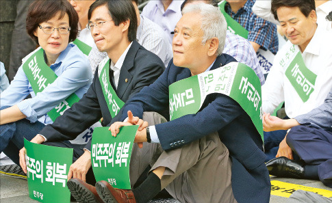 김한길 민주당 대표(앞줄 오른쪽)가 23일 청계광장에서 열린 ‘국정원 개혁 촉구 국민보고대회’에 참석해 굳은 표정으로 앉아 있다. 연합뉴스