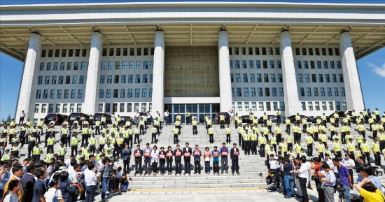 < 철통 경비 > 경찰들이 4일 이석기 통합진보당 의원에 대한 체포동의안 처리를 앞두고 국회의사당을 둘러싸고 있다. 경찰들 앞에서 통진당 의원 및 당원들이 체포동의안 처리 반대 구호가 적인 팻말을 들고 서있다. 연합뉴스