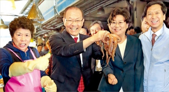 황우여 새누리당 대표(왼쪽 두 번째)가 11일 김기현 정책위 의장(맨 오른쪽), 이혜훈 최고위원 등과 함께 일본 원전  방사능 오염수 누출 사태로 어려움을 겪고 있는 서울 노량진 수산시장을 방문, 문어를 들어보이고 있다.  /연합뉴스 