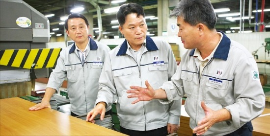안섭 보루네오가구 사장(가운데)이 인천 남동공단  본사 공장에서 직원들과 함께 가구 제작에 대해 얘기하고 있다.  /김희경 기자