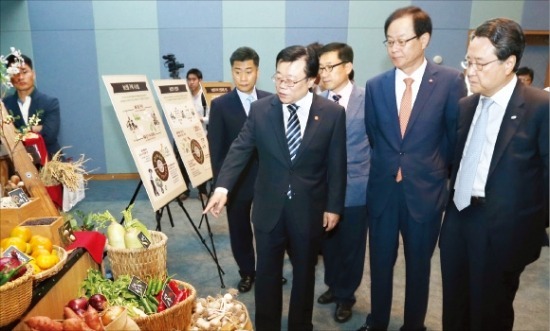 농림축산식품부와 CJ그룹은 16일 국산 농산물 구매를 확대하기 위해 ‘농업과 기업의 상생·동반성장 협약’을 맺었다. 이동필 농식품부 장관(왼쪽부터)과 김철하 CJ제일제당 대표, 유장희 동반성장위원회 위원장이 협약식 후 농산물 유통 과정을 보여주는 전시물을 보고 있다. 연합뉴스