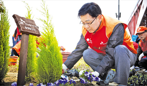 구자영 SK이노베이션 부회장과 직원들이 서울 한강공원에서 꽃길 만들기 봉사활동에 참여해 꽃을 심고 있다.  SK이노베이션 제공 