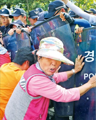 경남 밀양 송전탑 공사를 반대하는 주민들이 1일 공사현장 길목에서 경찰과 몸싸움을 벌이고 있다. /연합뉴스