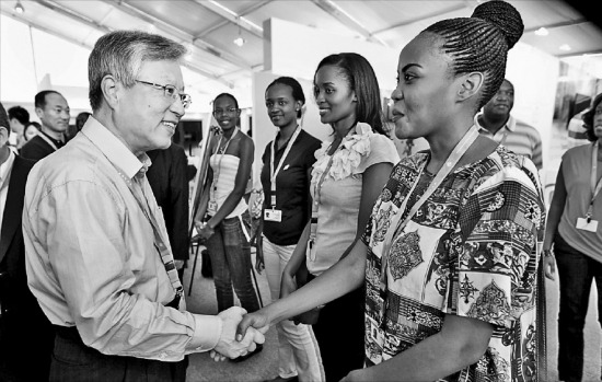 ‘아프리카 혁신 정상회의 2013’에 참석하기 위해 르완다 수도 키갈리를 방문 중인 이석채 KT 회장(왼쪽)이 행사를 하루 앞둔 27일(현지시간) 전시장을 방문해 르완다 대학생 자원봉사자를 격려하고 있다. KT 제공