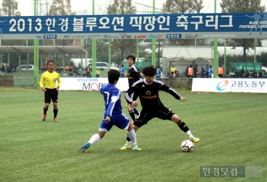 2일 충북 청주시 탄금대축구장에서 열린 '2013 한경직장인축구리그 최강전' 첫날 예선리그에서 현대성우오토모티브코리아(검은색 상의)와 중외제약(파란색 상의) 선수들이 공을 사이에두고 경합을 펼치고 있다. 유정우 기자 / 사진= 신성일pd ssi@hankyung.com