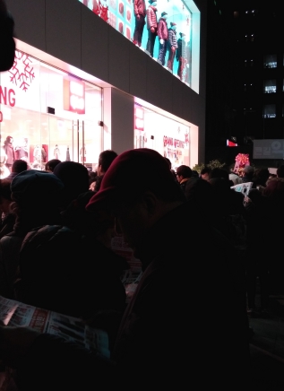 22일 새벽 유니클로 강남역삼점 개장을 기다리며 한 소비자가 광고지를 읽고 있다.