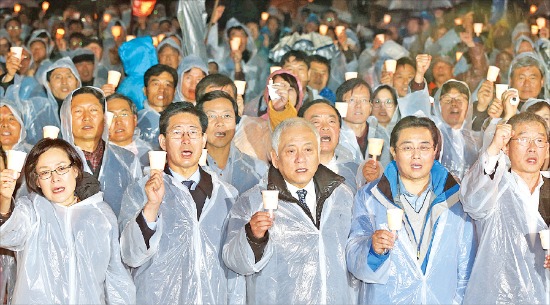 김한길 대표(앞줄 왼쪽 세 번째), 전병헌 원내대표(네 번째)와 민주당 의원들이 지난 9일 서울광장에서 열린 ‘민주주의 회복과 국정원 개혁 촉구 9차 국민결의대회’에서 촛불을 들고 구호를 외치고 있다. 연합뉴스