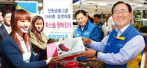 신한금융그룹은 지난달 16일 서울 태평로 신한은행 본점에서 ‘1사 1촌 결연마을 특산품 판매장터’를 열고 강원 횡성 등 5개 마을 주민들과 함께 농산물을 판매했다. 한동우 신한금융 회장(오른쪽 첫 번째)과 서진원 신한은행장(두 번째)이 특산품을 팔고 있다.  /신한금융그룹 제공 