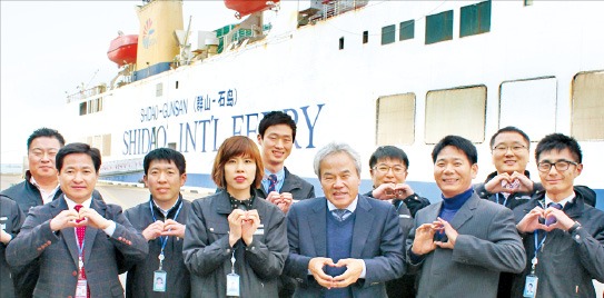 석도국제훼리 직원들이 군산항에 정박중인 훼리선스다오호 앞에서 사랑의 하트를 그려보이고 있다. 석도국제훼리 제공