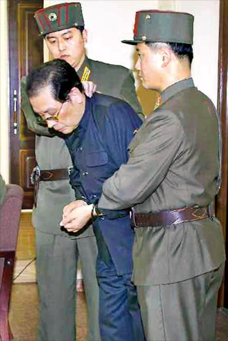 < 2인자의 최후 > 장성택 전 북한 국방위원회 부위원장이 지난 12일 국가안전보위부원 2명에게 목과 팔을 잡히고 두 손이 묶인 채 특별군사재판장에 들어서고 있다. 그는 사형 선고 직후 처형됐다. 연합뉴스
