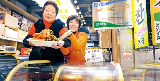 권영삼 강원반찬 사장(왼쪽)이 딸 배화자 씨와 함께 개폐형 진열대에서 꺼낸 알타리 김치를 내보이고 있다. 신경훈 기자 nicerpeter@hankyung.com 