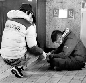 다시서기 희망지원센터 현장 상담원이 지난달 31일 밤 지하철 서울역 통로에 쓰러져 자고 있던 노숙인에게 다가가 상담하고 있다. 홍선표 기자