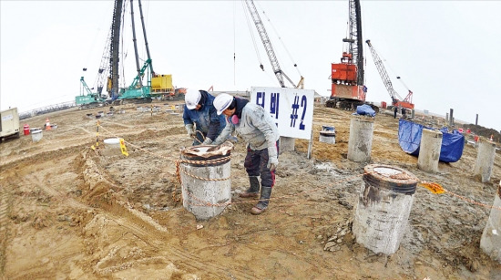 < 새만금은 공사 중 > 두산중공업 직원들이 새만금산업단지 2공구 매립지 내 열병합발전소 부지에서 연약한 지반을 보강하기 위해 땅속 45ｍ까지 박은 강철기둥을 점검하고 있다. 정동헌 기자 dhchung@hankyung.com