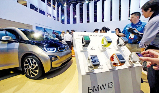 라스베이거스에서 열리고 있는 ‘CES 2014’ 에서 삼성전자 관계자들이 7일(현지시간) ‘갤럭시 기어’로 BMW의 전기차 i3를 제어하는 기능을 소개하고 있다. 삼성전자 제공
