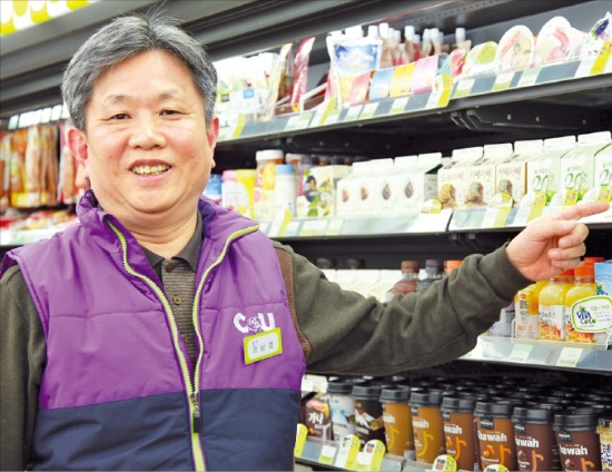 정남훈 CU 삼성1호점 사장이 판촉행사 중인 우유 제품을 가리키고 있다.  BGF리테일 제공 