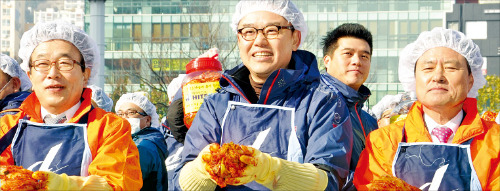 김인규 하이트진로 사장(가운데)과 허남식 부산시장(오른쪽), 서병수 새누리당 의원(왼쪽)이 지난해 12월 부산역 광장에서 열린 ‘사랑의 김장 담그기’ 행사에서 직접 담근 김장김치를 들어보이고 있다.  /하이트진로 제공
  