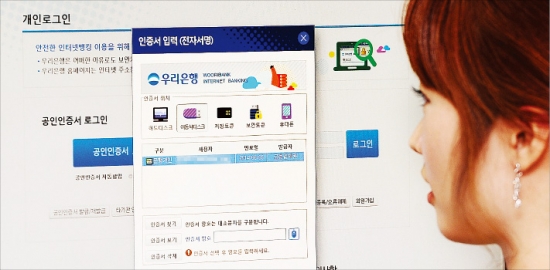 시중 은행 공인인증서 화면을 바라보고 있는 한 고객. 