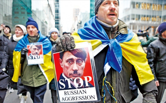 < “푸틴은 히틀러” > 미국 뉴욕에서 2일(현지시간) 시위대가 블라디미르 푸틴 러시아 대통령의 얼굴을 히틀러처럼 합성한 사진을 들고 러시아의 우크라이나 크림자치공화국 군대 파견을 반대하는 시위를 벌이고 있다. 뉴욕AFP연합뉴스