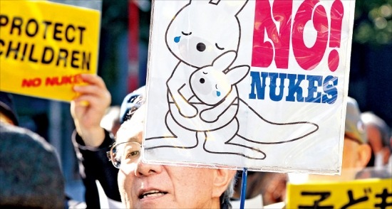 < 일본인 절반 이상은 “재가동 반대” > 일본 정부의 원전 재가동 방침에 반대하는 시위대들이 지난 15일 도쿄 시내에서 플래카드를 들고 거리행진을 하고 있다. 도쿄AFP연합뉴스