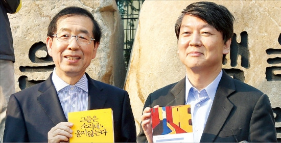 < 석달만에 만난 박원순·안철수 > 박원순 서울시장(왼쪽)과 안철수 새정치민주연합 공동 창당준비위원장이 23일 서울 교보문고 앞에서 서로에게 선물할 책을 들고 사진을 찍고 있다. 연합뉴스