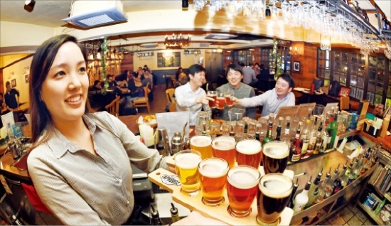 서울 이태원의 하우스맥주 전문점 ‘라일리스 탭하우스’에서 직원이 네 종류의 맥주를 맛볼 수 있는 샘플러를 들어보이고 있다. 허문찬 기자  sweat@hankyung.com