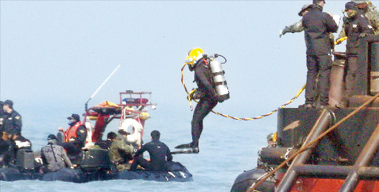 < 바닷속으로 > 한 민간 잠수사가 24일 공기공급 호스를 연결한 표면공급식 잠수장비(SSDS)를 착용하고 세월호 침몰 해상에서 수색을 위해 바다로 뛰어들고 있다. 이 잠수장비를 사용할 경우 잠수사는 더 깊은 곳에 들어가 수색할 수 있다. 연합뉴스
