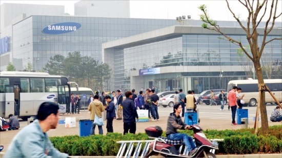 지난 25일 시안고신종합보세구에 있는 삼성전자 반도체 공장 입구에서 근로자들이 퇴근 통근버스를 기다리고 있다. 20일 가동에 들어간 삼성전자 반도체 공장은 내달 9일 공식 준공식을 한다. 김태완 특파원