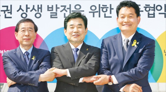 새정치민주연합의 박원순 서울시장 후보(왼쪽부터), 김진표 경기지사 후보, 송영길 인천시장 후보가 21일 광화문 광장에서 ‘수도권 상생발전을 위한 공동협약식’을 마치고 손을 맞잡고 있다. 연합뉴스