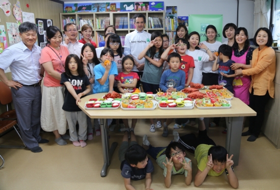 지난 5월 27일 서울 강북구 산 지역아동센터에서 BNP파리바 임직원들이 아이들과 함께 요리실습시간을 가진 뒤 사진을 촬영하고 있다. 뒷줄 중앙 요리스 디역스 한국 BNP파리바 대표, 좌측에서 세 번째 이돈주 전국지역아동센터협의회 이사장, 우측에서 세 번째 김진 BNP파리바은행 이사