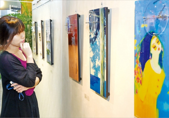 서울 중림동 한경갤러리를 찾은 한 관람객이 16일부터 열리는 ‘째깍째깍 아트 스펙트럼-그림이 있는 벽시계’전에 출품된 작품을 감상하고 있다. 강은구 기자 egkang@hankyung.com