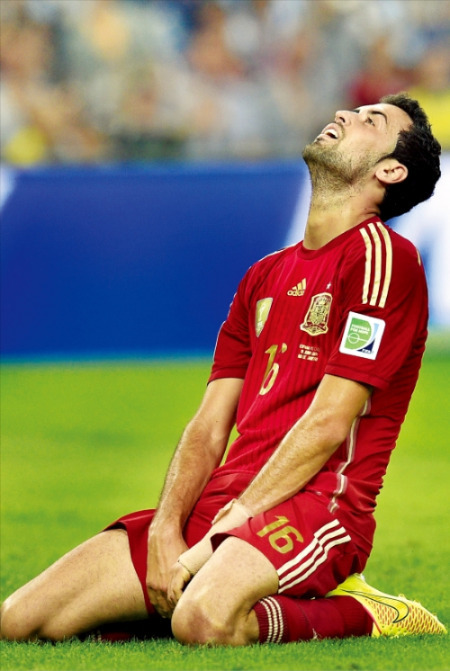 < 이럴수가 … > 디펜딩 챔피언 스페인이 19일(한국시간) 칠레에 2-0으로 패하며 16강 진출에 실패했다. 미드필더 세르히오 부스케츠(26·FC바르셀로나)가 경기가 끝난 뒤 망연자실한 표정으로 앉아 있다. EPA연합뉴스