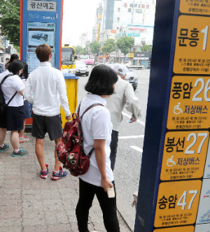 광주광역시 시내버스 노동조합이 12년 만의 총파업에 들어간 23일 광주 운암동의 한 버스정류장에서 시민들이 버스를 기다리며 애를 태우고 있다. 연합뉴스