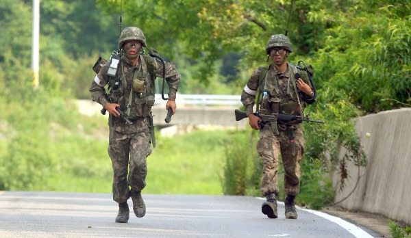 동부전선 GOP에서 동료 병사들을 살해한 뒤 무장탈영한 임모 병장 체포작전 이틀째인 23일 오전 강원도 고성군 거진읍 명파리와 마달리 사이 도로에서 작전에 참가한 무전병이 전진 방향에서 교전의 총성이 들리자 지원하기 위해 뛰고 있다/연합뉴스