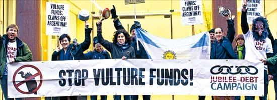 벌처 펀드에 반대하는 사람들이 미국 연방대법원 판결을 하루 앞둔 지난달 15일 아르헨티나에 소송을 제기한 엘리엇 어소시에이츠 영국 런던 지점 앞에서 독수리 가면을 쓴 채 시위하고 있다. 주빌레부채캠페인 제공