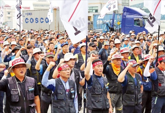 민주노총 공공운수노조 화물연대 부산지부가 14일 부산 북항 신선대컨테이너터미널 앞에서 구호를 외치고 있다. 화물연대는 화물운송 노동자 생존권 보장을 위한 법안의 국회 조기 통과를 촉구하며 이날 하루 파업을 벌였다. 연합뉴스