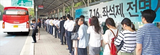 < 언제 타려나… > 광역버스 입석 금지가 시행된 첫날인 16일 오전 경기 용인시 수지 지역난방공사 버스정류장에서 시민들이 길게 줄지어 버스를 기다리고 있다. 연합뉴스