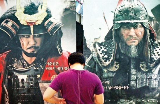 영화 ‘명량’을 보기 위해 서울의 한 극장을 찾은 관객이 포스터 앞에 서있다. 연합뉴스