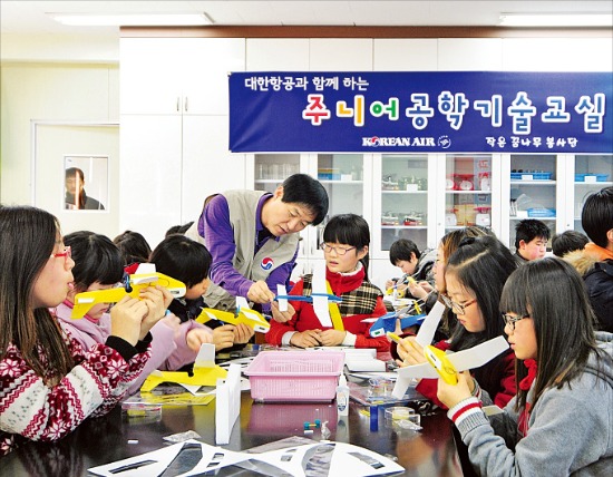 대한항공 항공우주사업본부 직원이 부산 엄궁동 학진초등학교에서 열린 ‘주니어 공학 기술교실’에서 모형비행기를 들고 학생들에게 비행기의 작동 원리를 설명하고 있다. 대한항공 제공
 