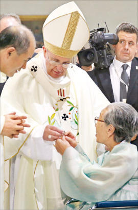 < 약자 곁으로 > 프란치스코 교황이 18일 서울 명동성당에서 ‘평화와 화해를 위한 미사’를 집전하기 전 위안부 출신 할머니를 만나 나비 모양의 뱃지를 선물받고 있다. 강은구 기자 egkang@hankyung.com
